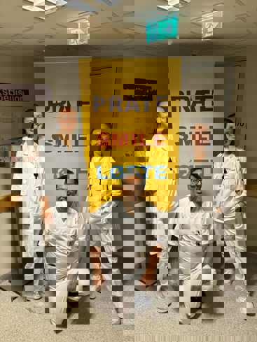 Bilde av tre LIS ved Skien sykehus foran en Prate-Smile-Løfte plakat