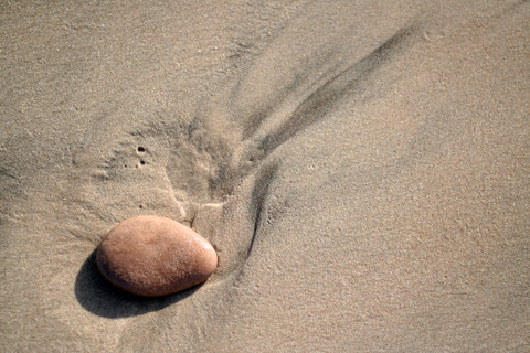 En sten på en sandstrand. Foto: Colourbox.com