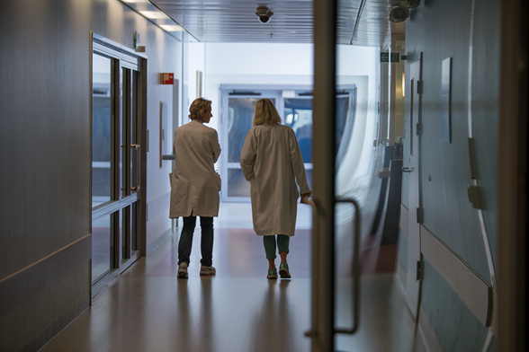 To leger går og prater i en tom sykehuskorridor. Foto: Thomas B. Eckhoff/Ahus