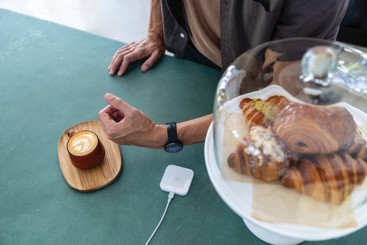 Mann som betaler en kaffe med klokken sin. Foto: Garmin