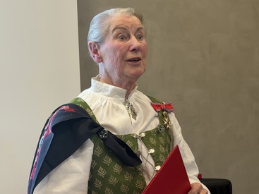 Bilde av Kirkengen fra overrekkelsen. Hun har grått, kortklippet hår, og har på seg bunad. Denne har hvit skjorte, sølje i halsen, sort sjal med broderte blomster i rødt og rosa, og bunadsvesten er lysgrønn med sølvknyting i front. På venstre skulder henger dekorasjonen hun er tildelt: En rød sløyfe med hvitt og blått i kantene, og en gullstjerne. Hun holdet på en rød mappe. 