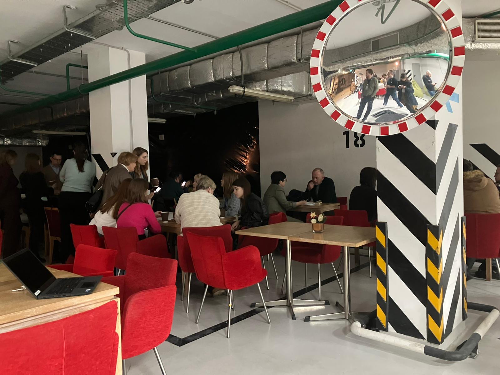 Forleser og tilh&oslash;rere i et tilfluktsrom. Ingen vinduer.