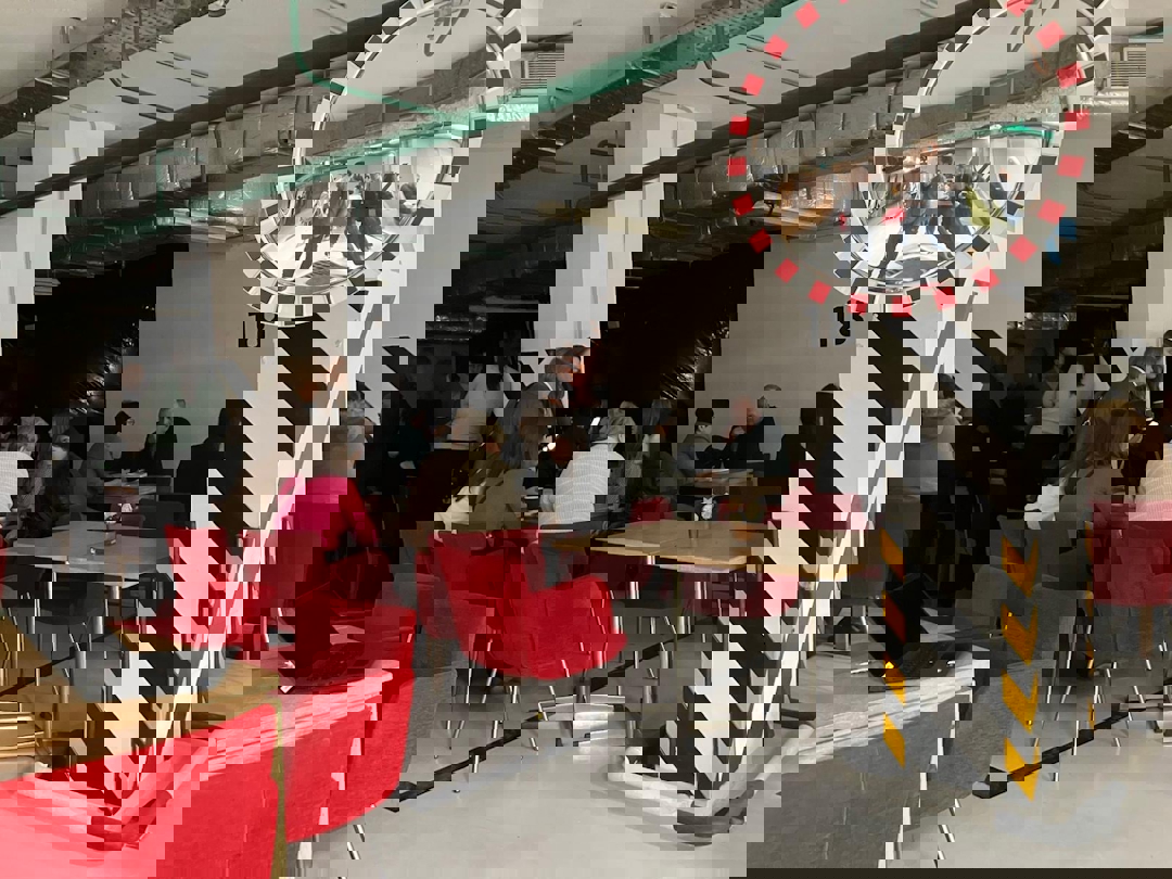 Forleser og tilhørere i et tilfluktsrom. Ingen vinduer.