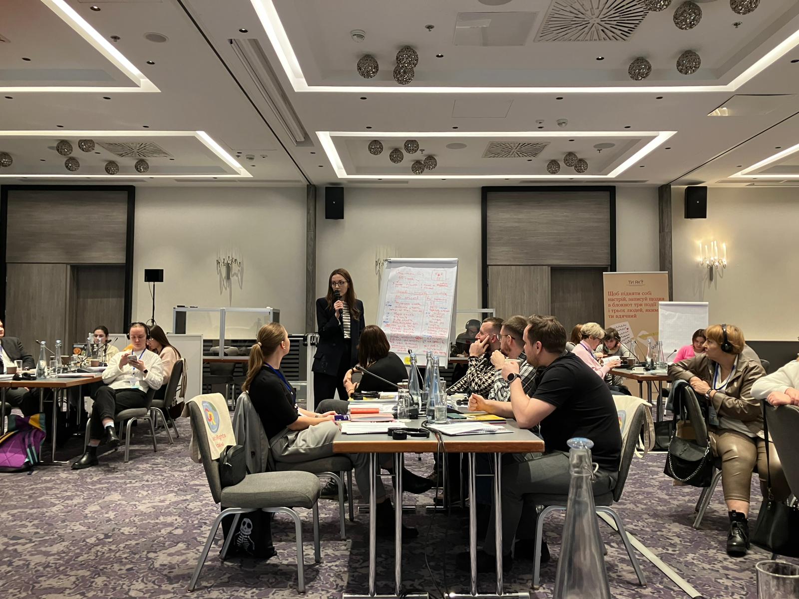 En forelesningssal med foreleser og deltakere.