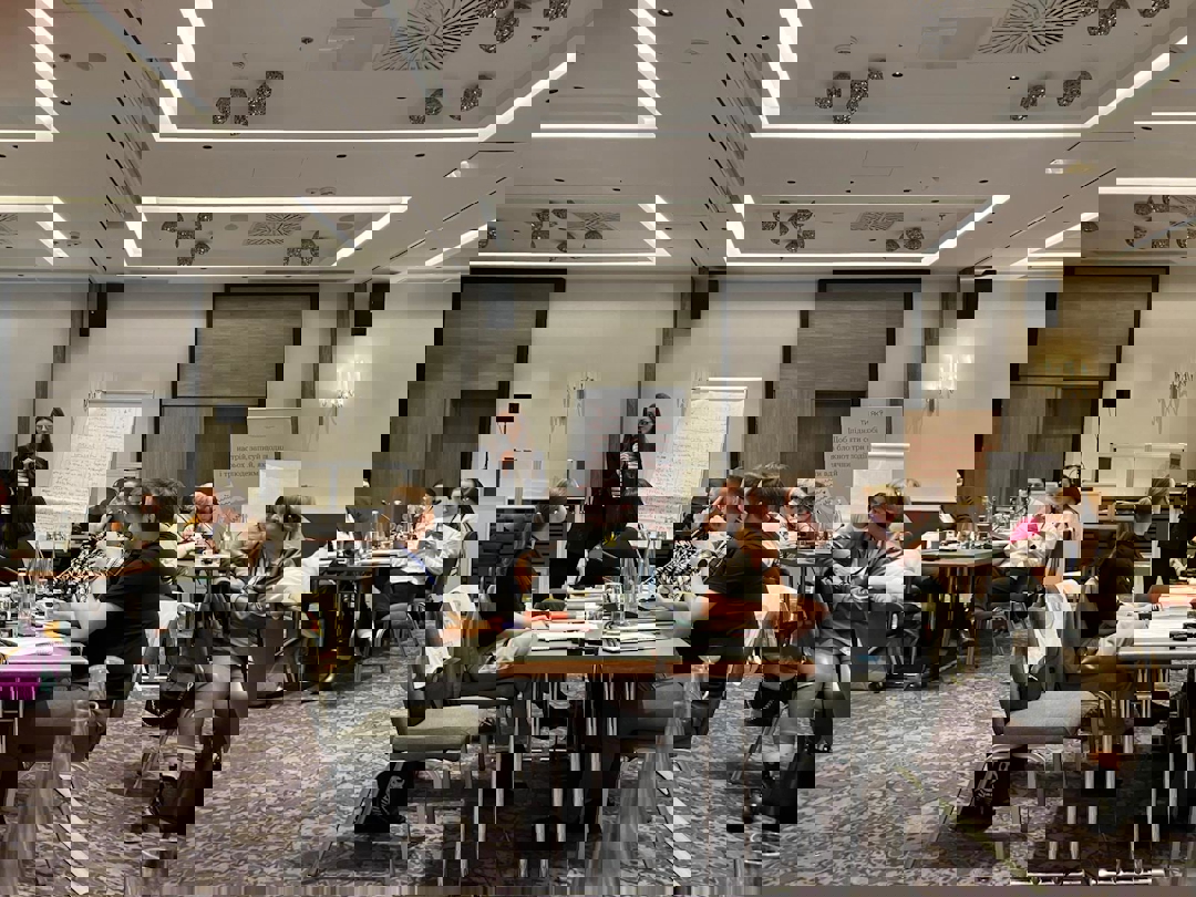 En forelesningssal med foreleser og deltakere.