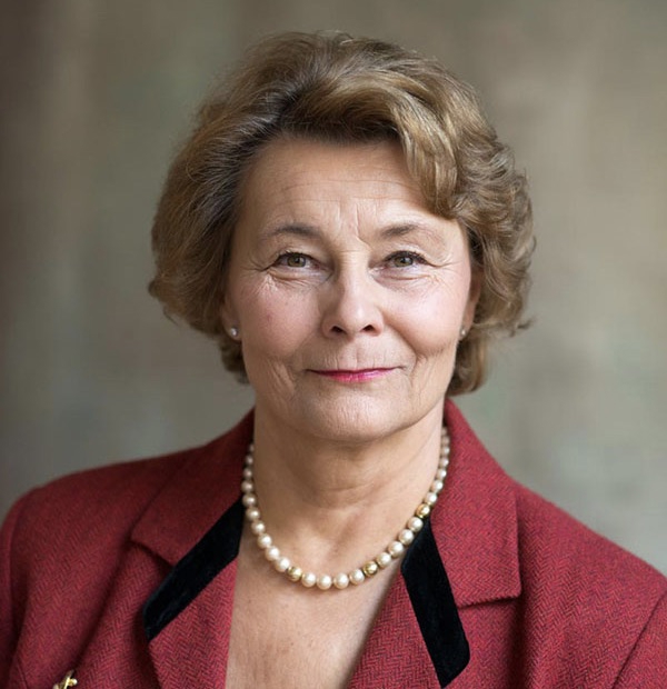 Kvinne, smiler, blondt hår, perlekjede, rød jakke