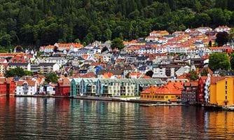 Bilde av Bergen. De fargerike bygningene i Bergen, Norge reflekteres i vannet i den travle havnen.