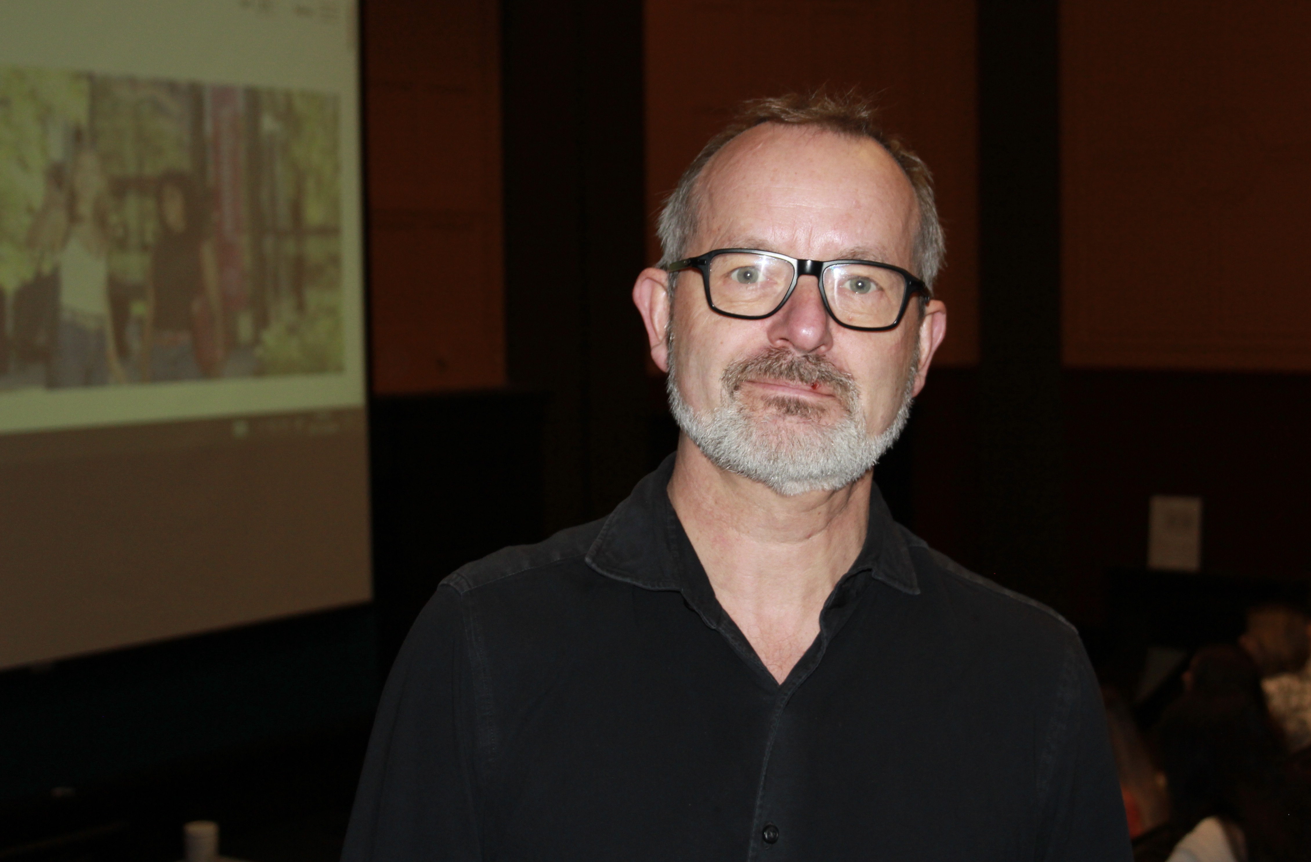 Voksen mann foran et auditorium med mennesker