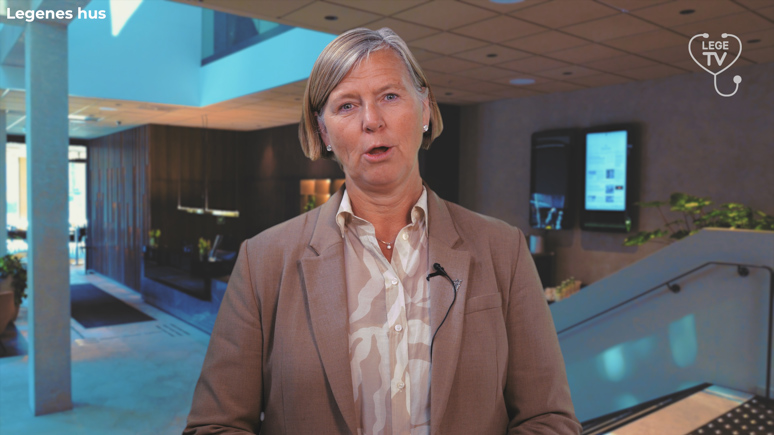 President i Legeforeningen, Anne-Karin Rime. Hun har lyst hår til øreflippene og sideskill, perleøredobber og beige dressjakke. Inni dressjakka har hun på seg en skjorte i naturhvit og beige. Hun holder på å si noe.