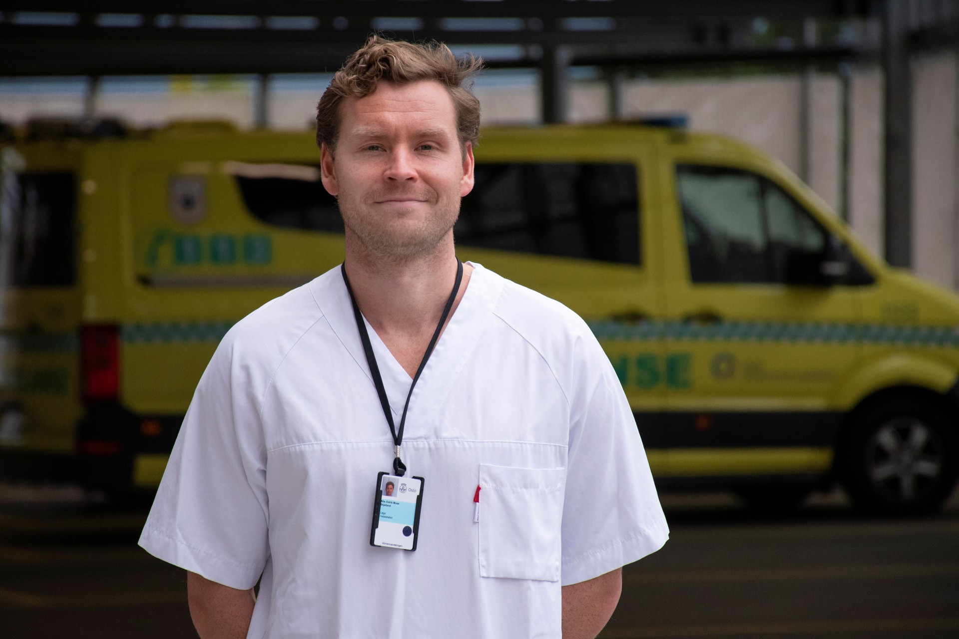 Mannlig lege ute foran ambulansebil