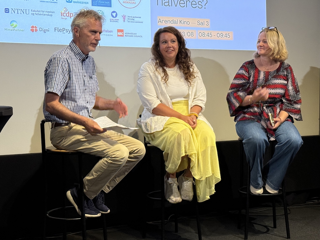 En mann og to kvinner på stoler på en scene.