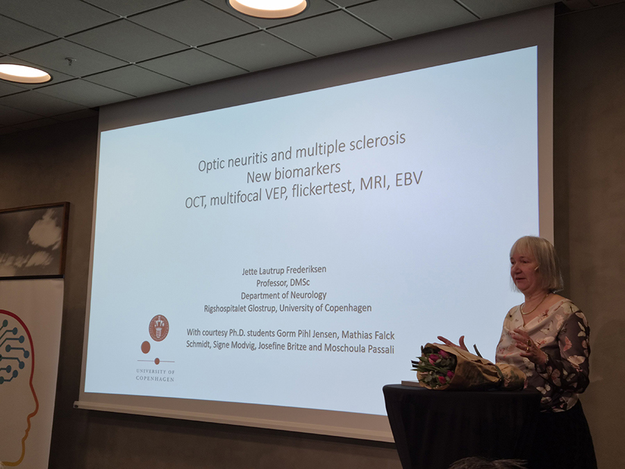 Bilde av Jette Lautrup Frederiksen på talerstolen mens hun holder en presentasjon.