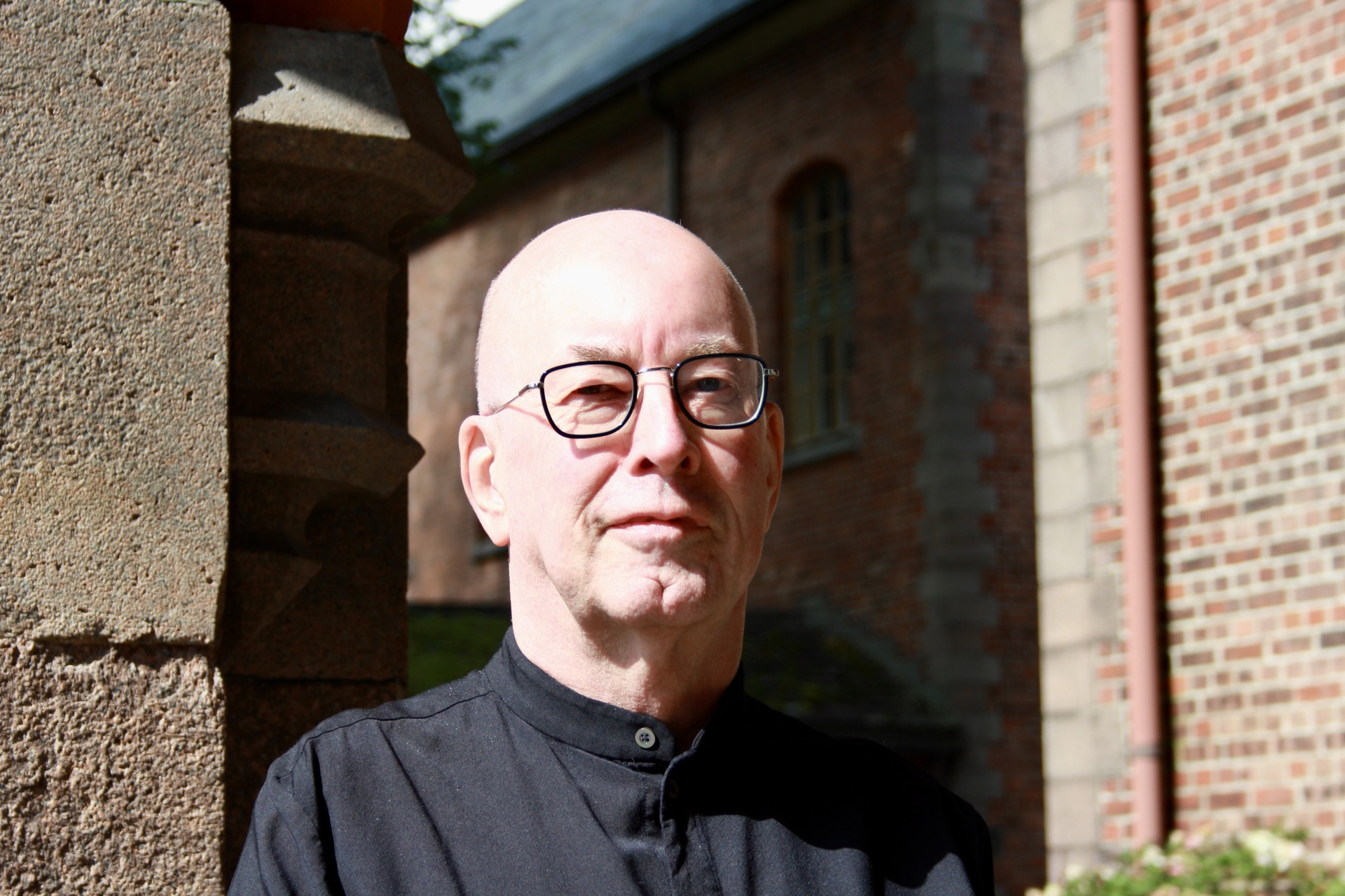 Bilde av Edvard Hauff utenfor mursteinsbygning på Gaustad sykehus.