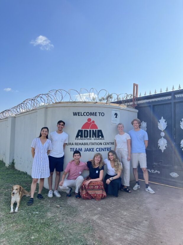 PÅ BESØK: Representanter fra MedHum utenfor Adina Stiftelsens rehabiliteringsklinikk i Nord-Uganda. Fra venstre: Anna Yang Arntzen, Anders Vagle, Daniel Masami Nishimura, Kristine Benedikte Arbo de Besche, Sol Agnete Stene Aglen, Vilde Hustad og Trym Øby Berntsen. Foto: MedHum