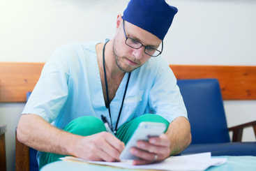 Mannlig lege skriver journal. Foto: Colourbox.