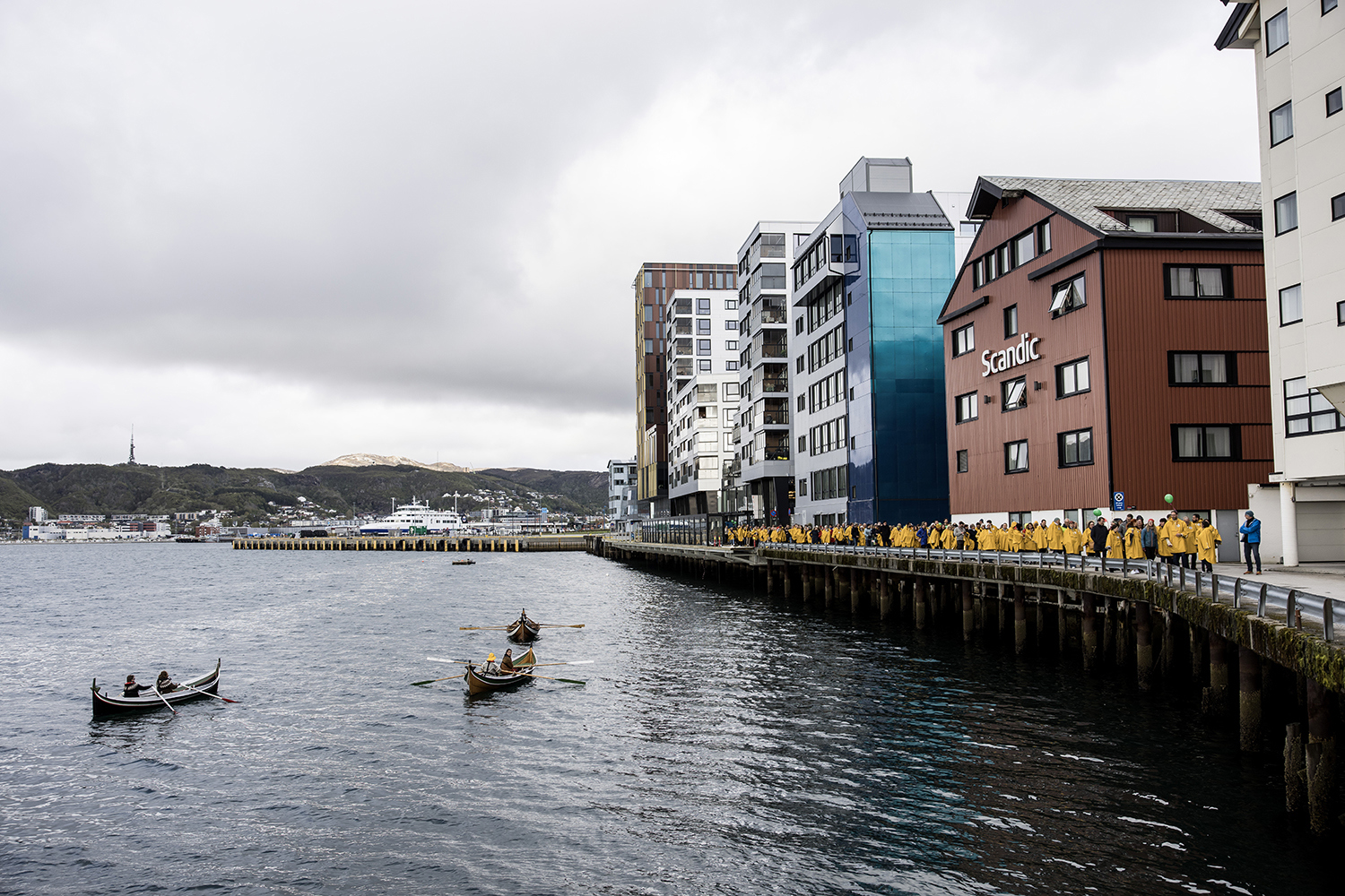 Nordlandsbåter på sjøen rett utenfor Scandic i Bodø. Landsstyremøtets deltakere deltagere til høyre i bildet med gule regnfrakker. 