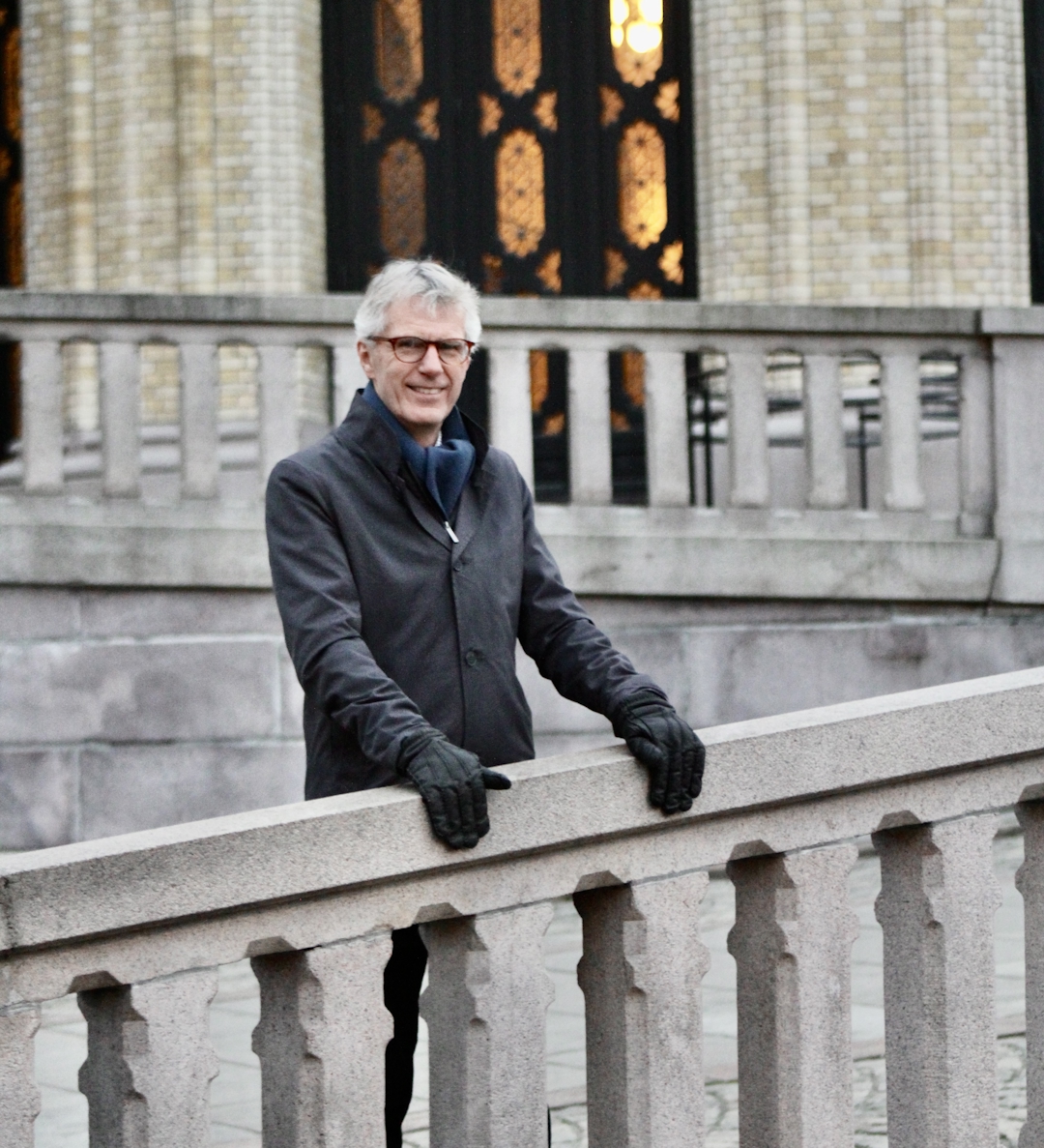 Mann med mørk jakke utenfor Stortinget.