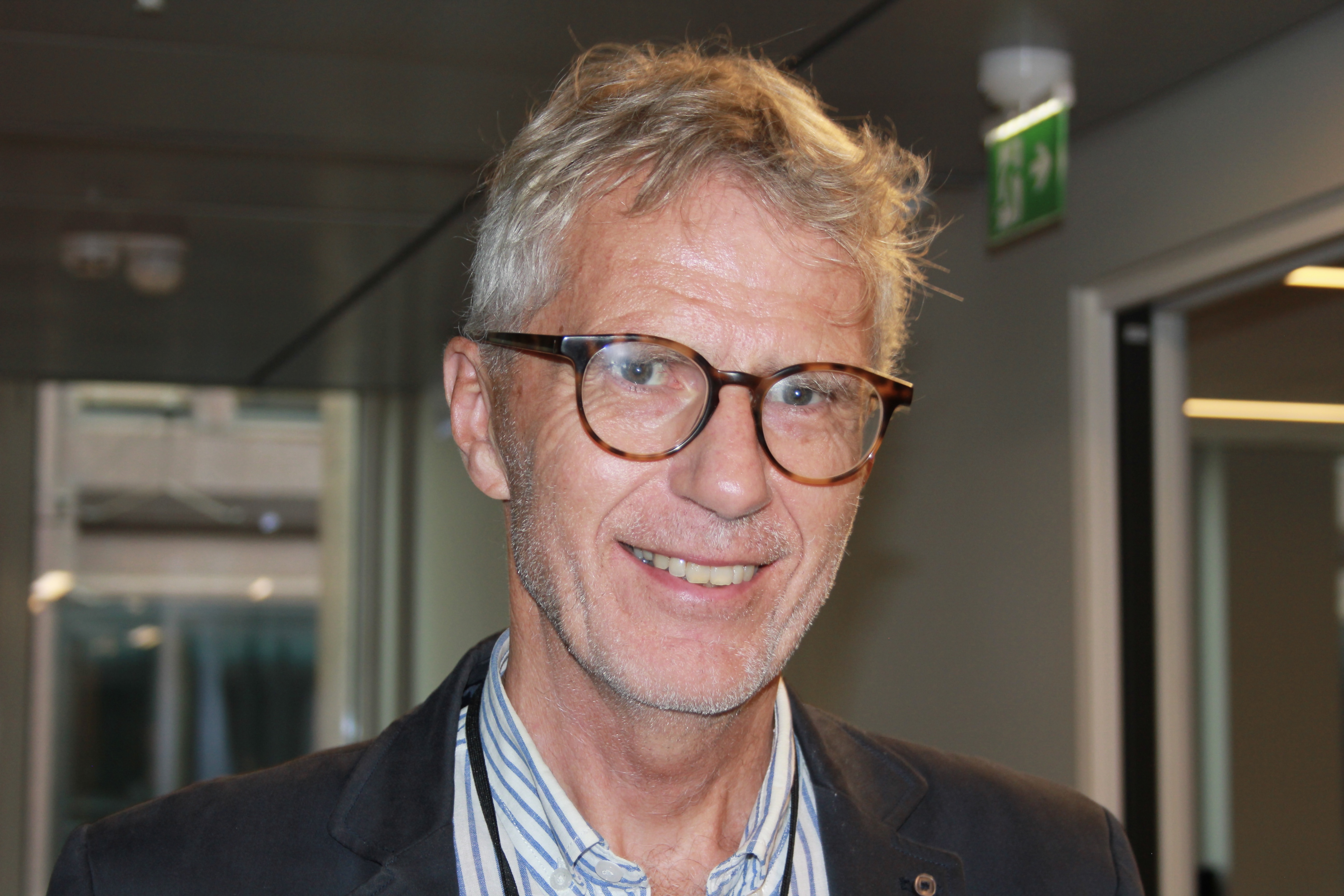 En smilende mann med briller og skjegg.