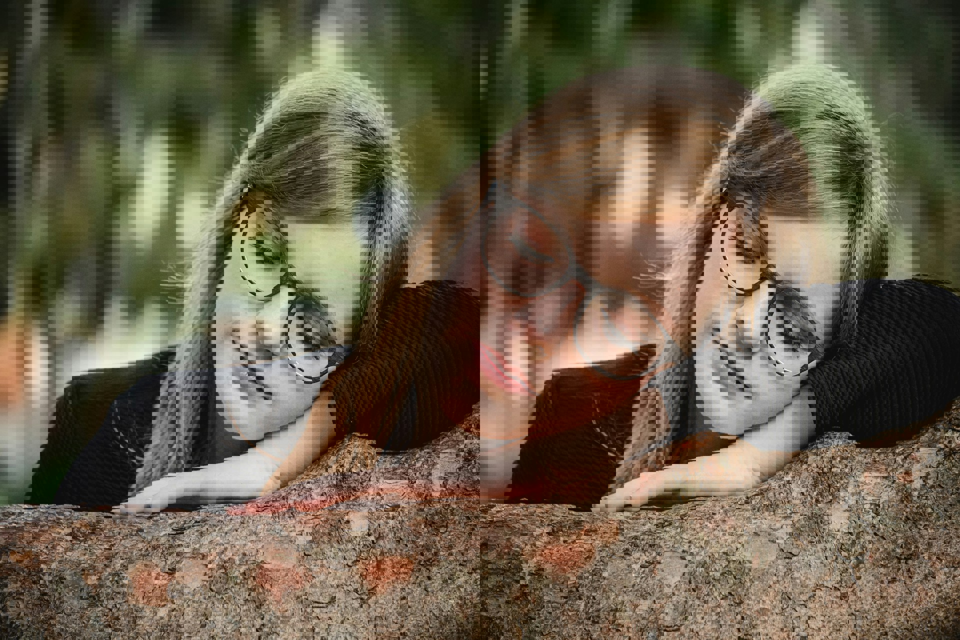 Illustrasjonsfoto av en ung kvinne som hviler hodet inntil en  trestamme.  Foto: Til Jentzsch, Unsplash
