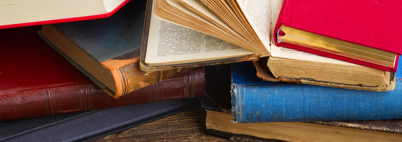 Gamle bøker som ligger oppå hverandre.