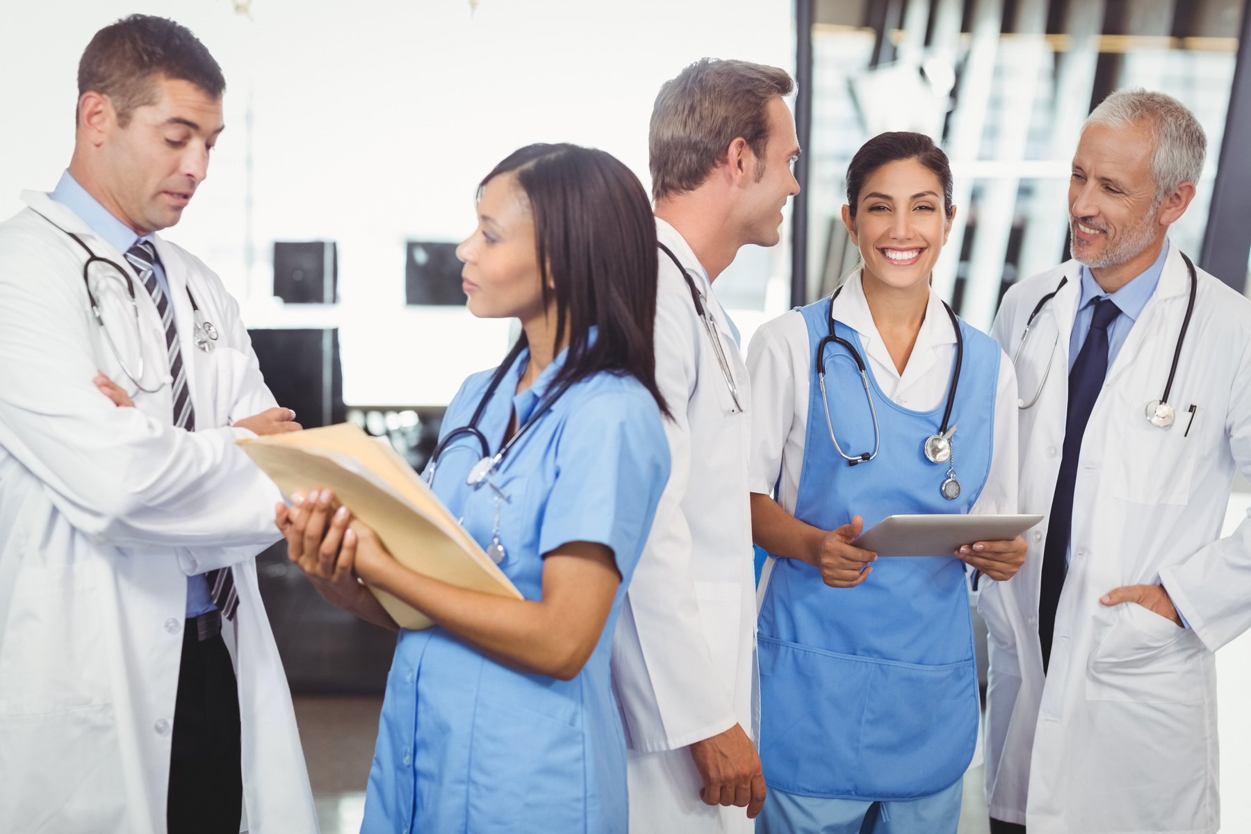 til høyre står to leger med en konvolutt, til venstre tre leger med en ipad