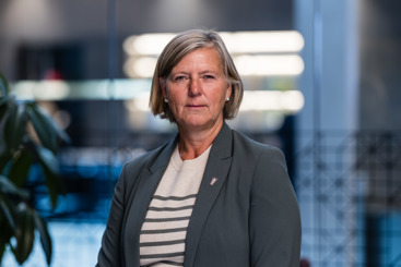 President i Legeforeningen, Anne-Karin Rime. Hun har lyst hår til rett nedforbi ørene og sideskill. Hun har perleøredobber i øreflippene, og har på seg en grå dressjakke med hvit og gråstripet genser inni. Hun ser alvorlig ut. Bakgrunnen er uskarp og lys.. 