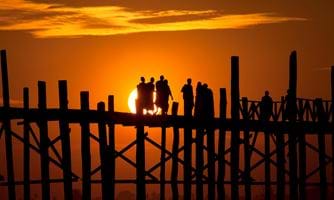 Mennesker på bro i soloppgang