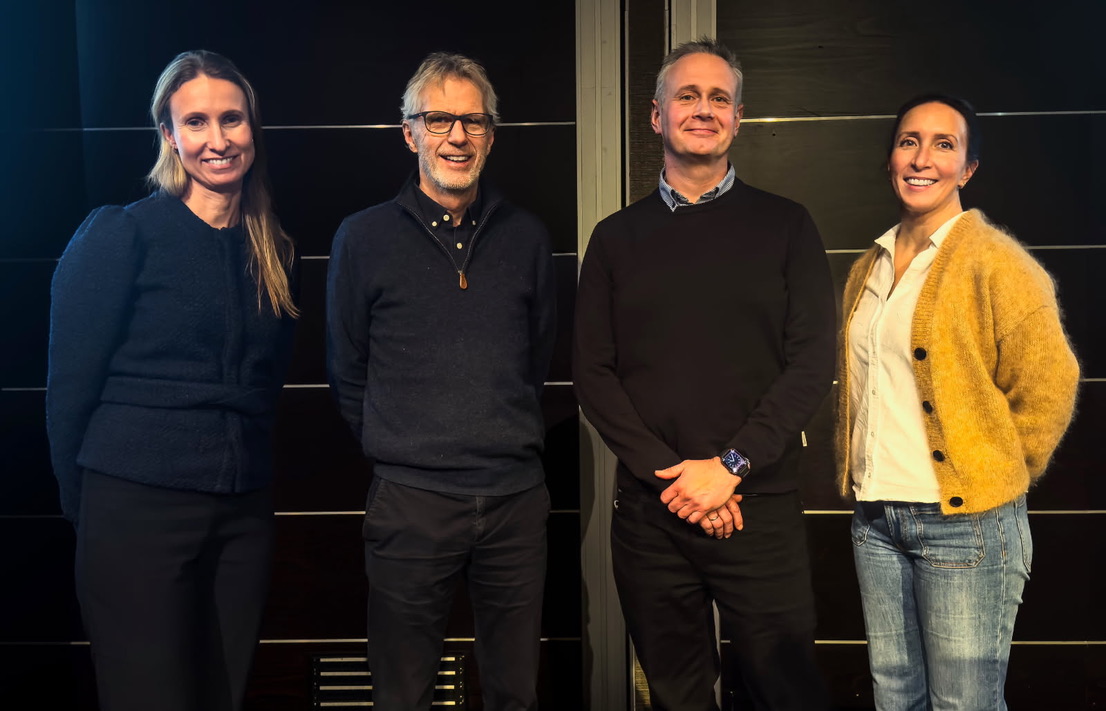 En kvinne i m&oslash;rke kl&aelig;r, to menn i m&oslash;rke kl&aelig;r og en kvinne i lys topp og gul jakke. M&oslash;rk bakgrunn.