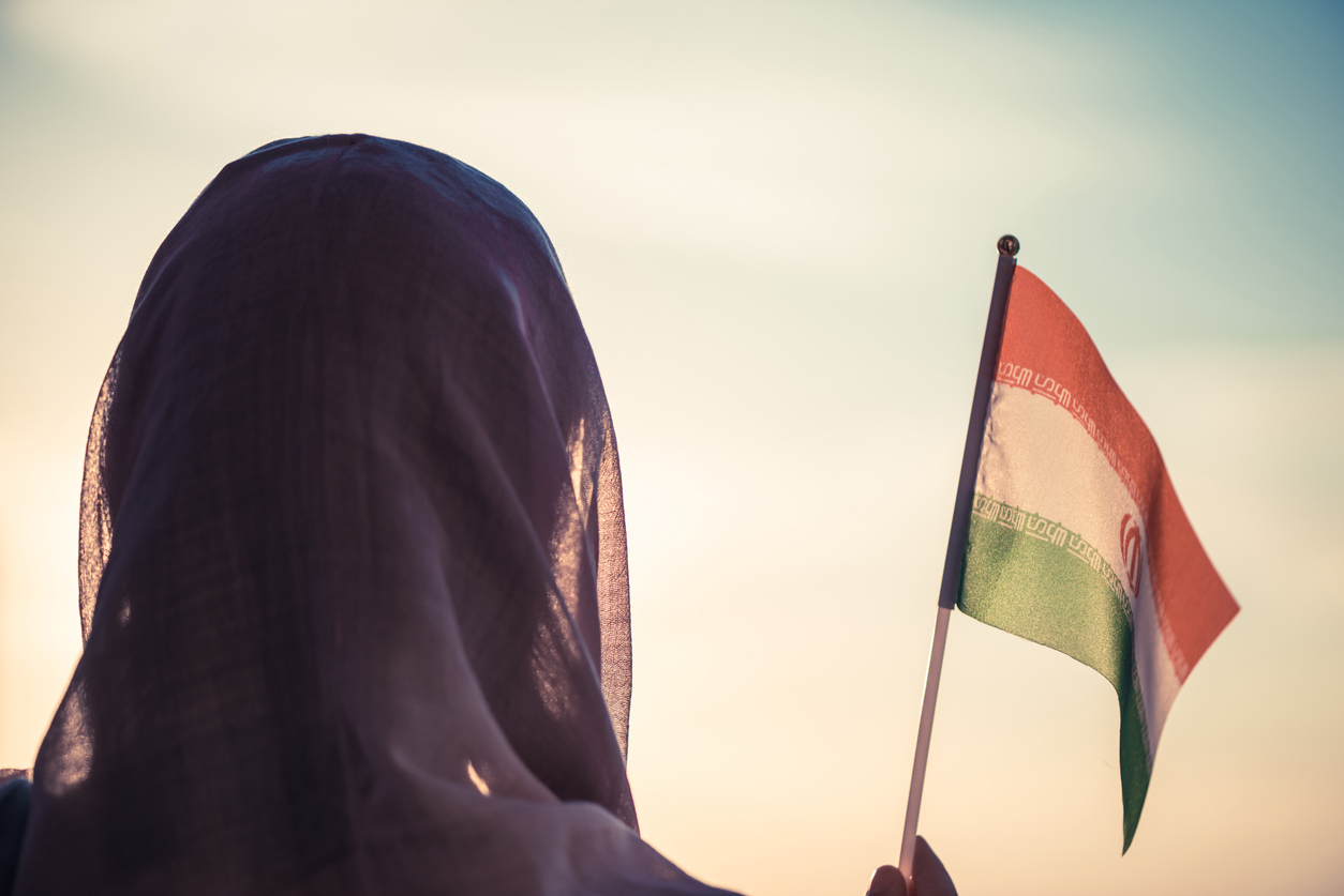 Dame med slør som holder et iransk flagg. Foto: Istockphoto.com