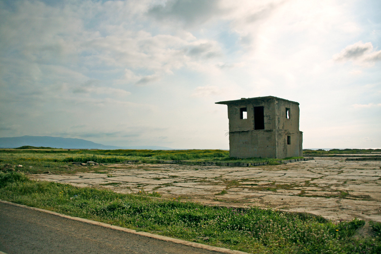 Forfallent murhus i to etasjer p&aring; gold mark. litt gr&oslash;nt gress.