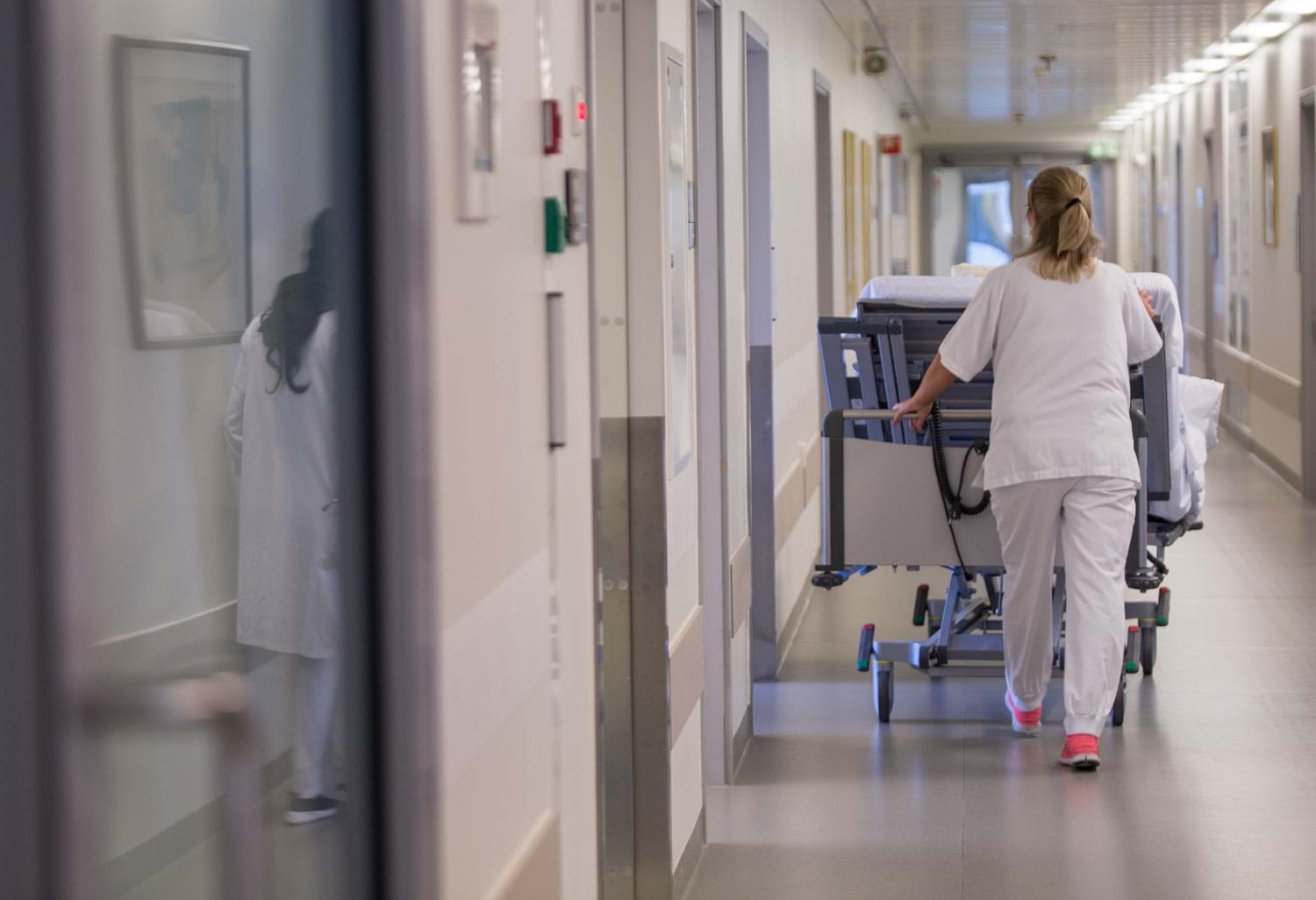 Sykepleier i en sykehus korridor som dyter en seng. Foto: Thomas B. Eckhoff