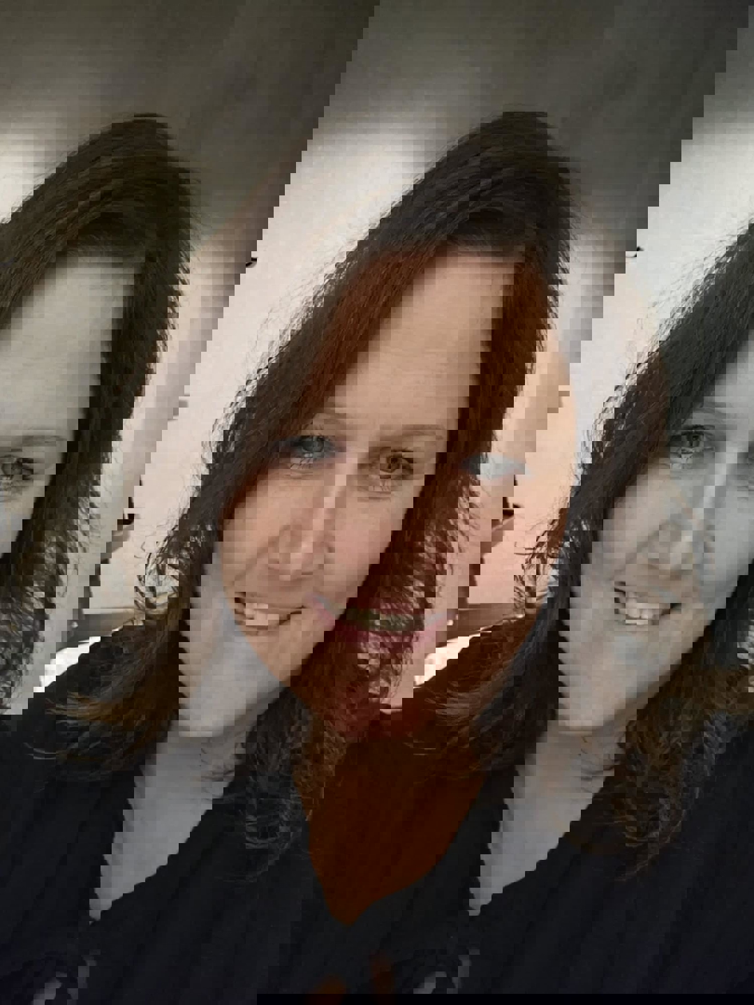 En smilende kvinne med mørkt hår.