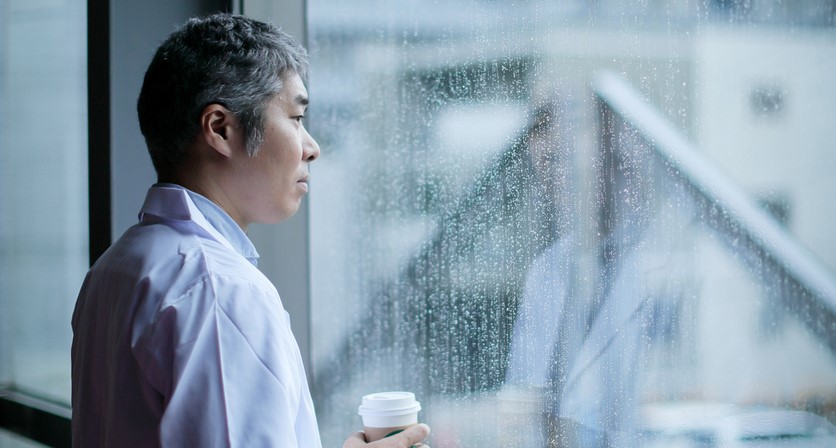 Mann som stirrer ut av vinduet på regnet. Foto: Istockphoto.com