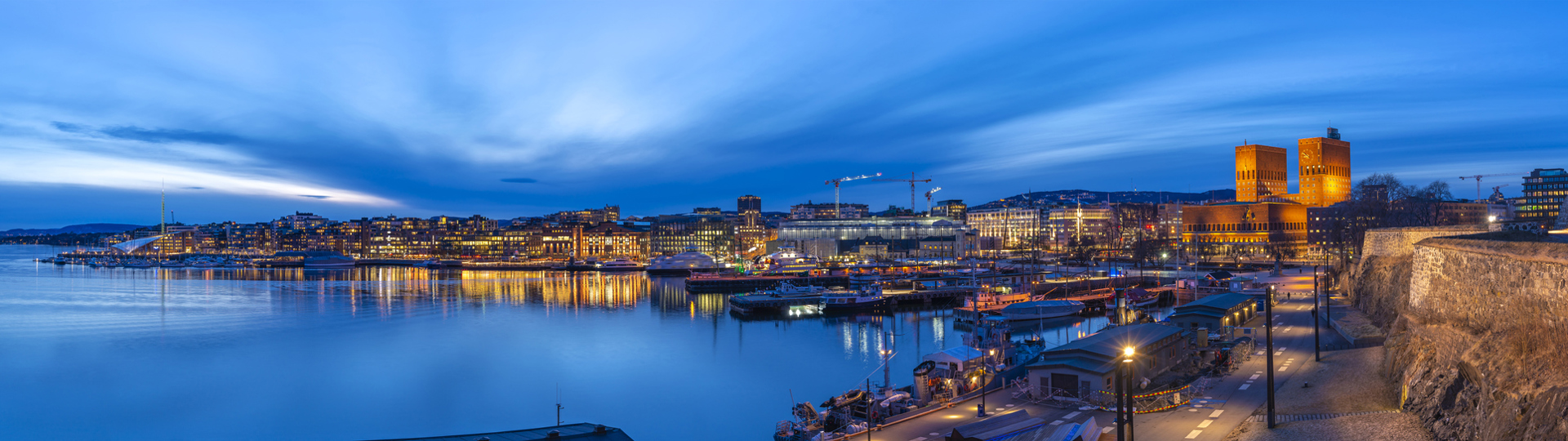 Oslo havn fra festningen med rådhuset og Akerbrygge om natten. Foto: Istockphoto.com Credit:Noppasin Wongchum